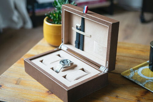Immagine di un orologio da collezione in una scatola di legno intagliata
