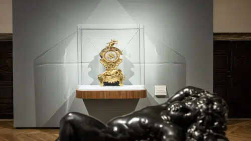 Immagine di una mostra di orologi con un orologio da tavolo in primo piano.