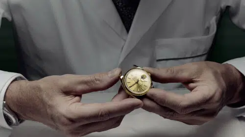Una persona che ripara un orologio, con attrezzi e parti di ricambio per la manutenzione
