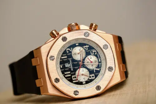 Una persona che indossa un orologio di lusso, con uno sfondo di una vetrina di orologi di lusso, che rappresenta la possibilità di vendere orologi di lusso.